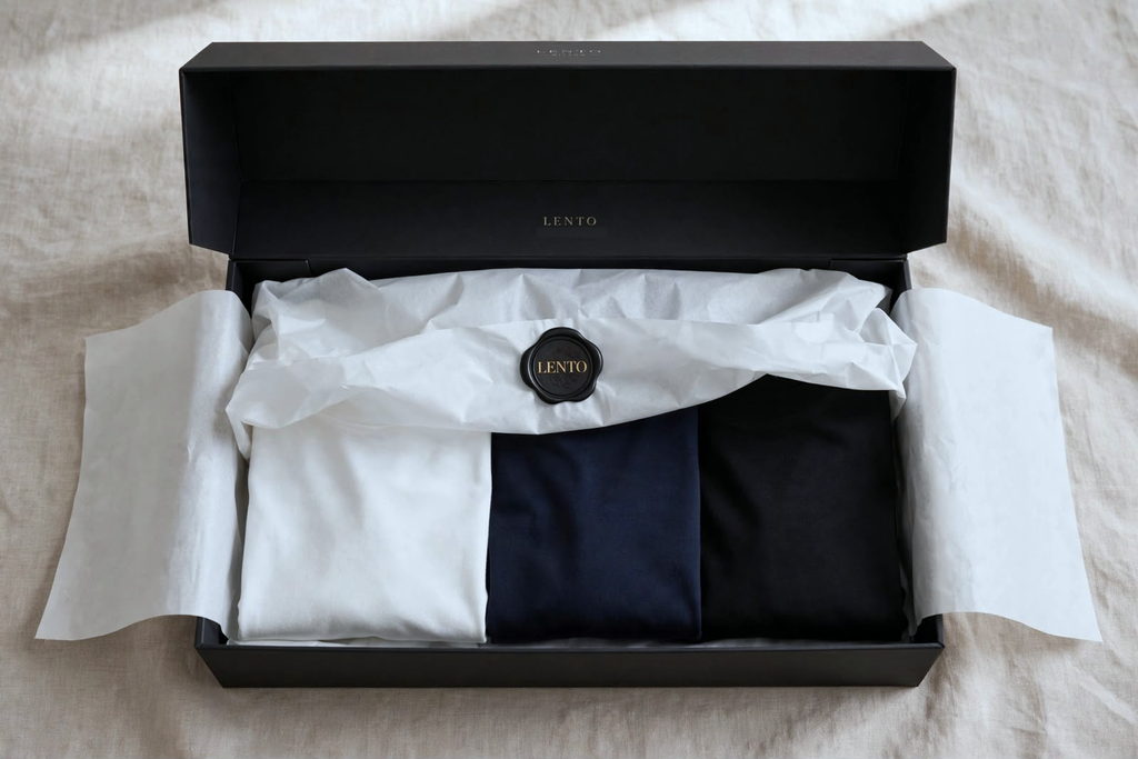 The box open, tissue paper folded back over the shirts, closed with a wax seal.