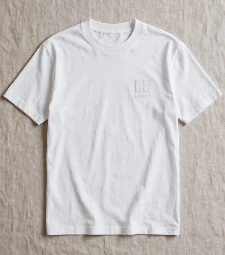 The white t-shirt laid flat, showing the ribbed crew neck and tonal chest mark.